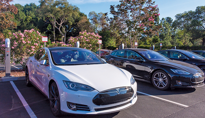 Tesla cars charging in their designated parking spaces at the Tesla headquarters in Palo Alto.