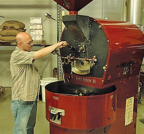 Fred Polzin, co-founder of Topeka-based PT’s Coffee Roasting Co., works on a refurbished roaster that will increase capacity fourfold.