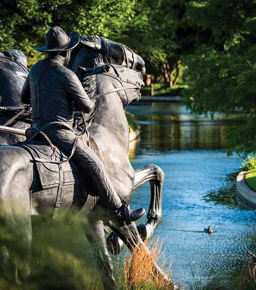 Part of the Oklahoma Landrun Monument overlooks the Bricktown Canal.