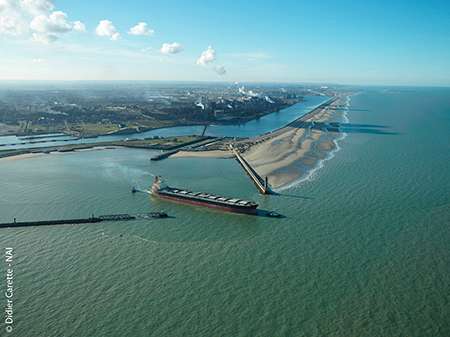 An ore carrier leave the Port of Dunkirk’s eastern outer harbor, just 90 minutes from the Strait of Dover. Behind it is the maritime dock. In the distance to the right are the jetties of the Western outer harbor.